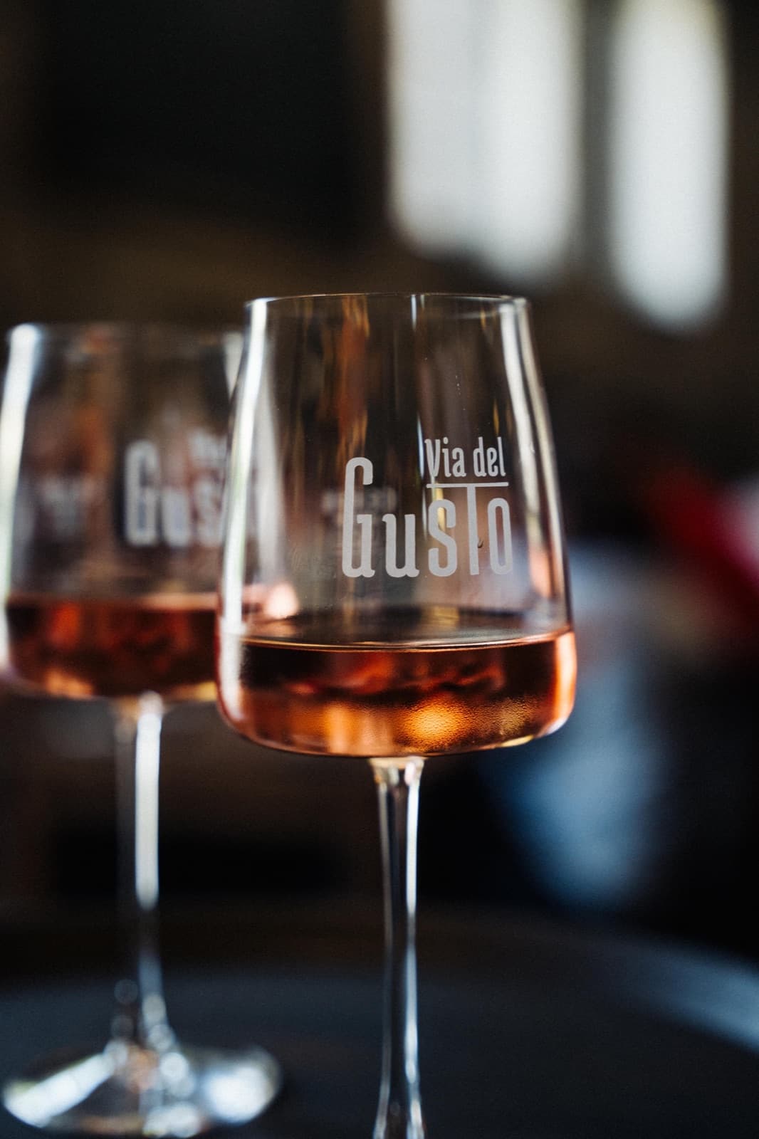 Zwei Gläser Rosé mit dem Via-del-Gusto-Schriftzug